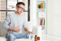 Older asian man experiencing stomach pain