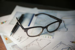 Bank statements with glasses and a pen