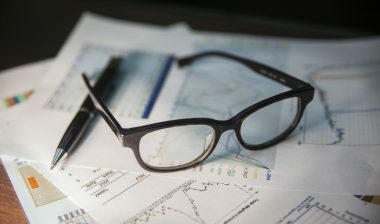Bank statements with glasses and a pen
