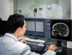 A technician views results of a CT scan.