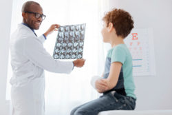 A doctor looks at a boy's CT scan.