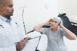 A doctor consults a woman undergoing cancer treatment