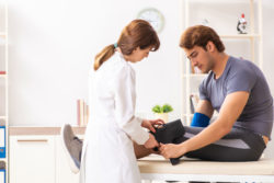 A doctor helps a man with a knee brace