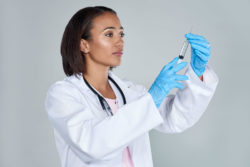 A doctor is holding a syringe.