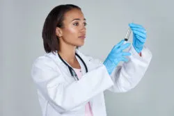 A doctor is holding a syringe.