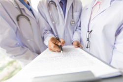 Three doctors discussing a medical record