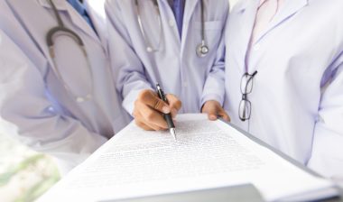 Three doctors discussing a medical record