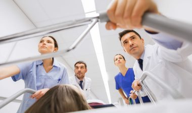Emergency room doctors push a gurney.