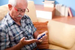 Elderly man with diabetes testing blood sugar