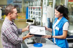 A man buying a shirt at a checkout counter