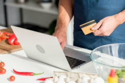 A man uses a credit card while shopping online.