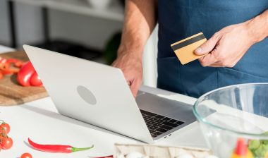 A man uses a credit card while shopping online.