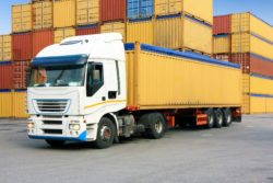 A truck hauls a cargo container from a port.