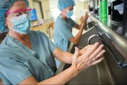 Two surgeons wash their hands.