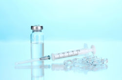 A syringe with vials on a blue background.