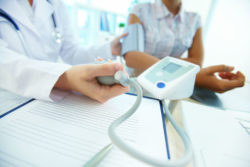 A physician takes a patient's blood pressure.