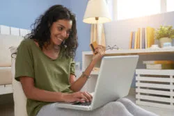 A woman is using a credit card online.