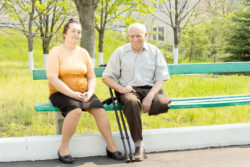 A woman and man sit on a park bench.