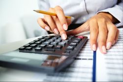 Woman on calculator with bank statement.