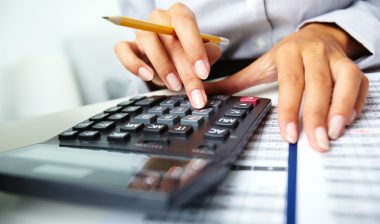 Woman on calculator with bank statement.