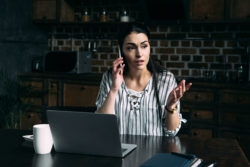 An upset-looking woman is talking on her smartphone.