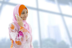 A woman in a bright scarf on her cell phone.