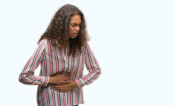 Woman experiencing pain in her torso.
