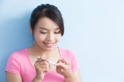 Woman holding blood glucose meter.