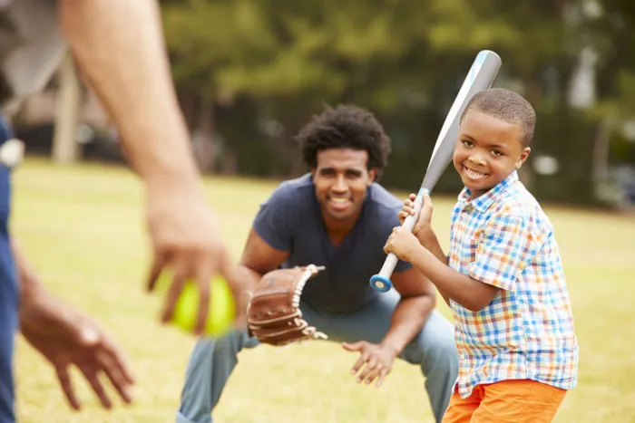 young boy holding Rawlings baseball bat