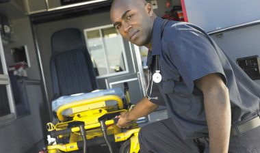 An EMT takes a gurney out of an ambulance