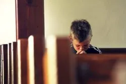 Boy praying in church