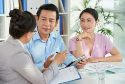 A couple wraps up paperwork with a bank officer.