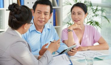 A couple wraps up paperwork with a bank officer.