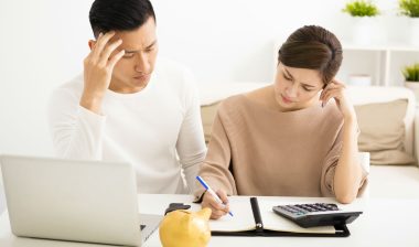 A concerned couple reviews banks statements