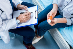 A patient reads the label on her medication.
