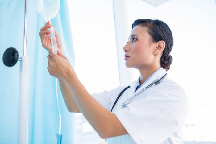 Doctor connecting IV drip containing Lemtrada