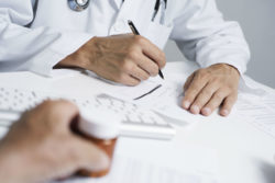 Doctor in labcoat writing a prescription