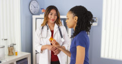 A doctor showing patient prescription bottle.
