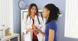 A doctor showing patient prescription bottle.