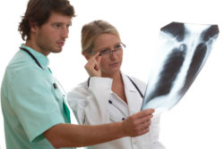 Two doctors look at a chest X-ray.