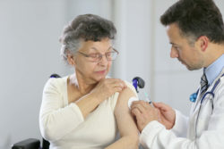 Elderly woman getting a vaccine from a doctor