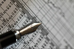 Close-up pf fancy pen and financial papers.
