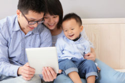 A family looks at a tablet.