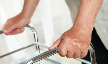 Close up of hands holding a walker