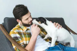 A man has a dog on his lap.