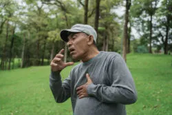 Man in the park experiencing heart problems