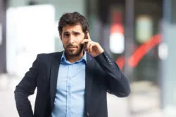 A man talks on a phone.