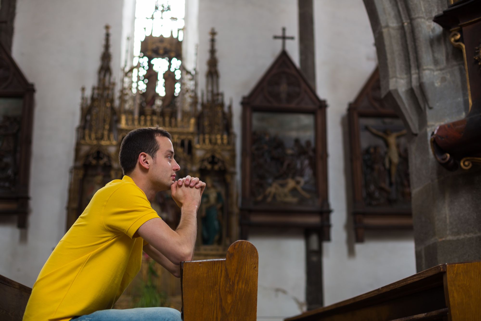 A man prays in a church.