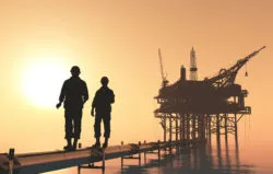 Oil workers walk near a platform.