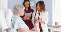 Patient talking to doctors in hospital bed